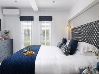 A bedroom with a bed and dresser at Costal Lodge at Seaham Hall, Seaham