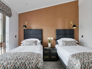 A bedroom with two beds and a bedside table at Costal Lodge at Seaham Hall, Seaham