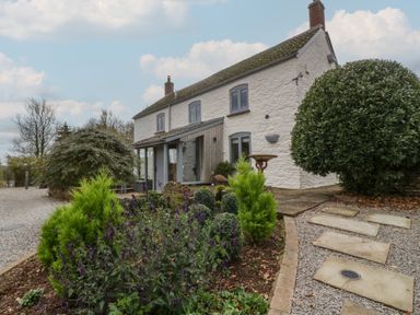 An exterior view of a house with garden and pathway at 3 bed property