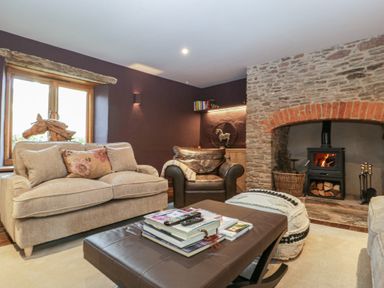 A living room with a wood stove and two sofas at 3 bed property 