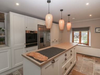 A kitchen with island, refrigerator, and oven at 3 bed property