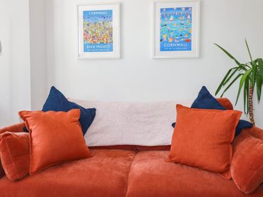 A sofa with pillows and wall art at Higher Tower Road