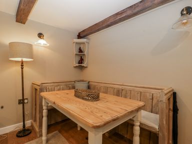 A dining room with a table and bench seating at 1 bed property in Usk