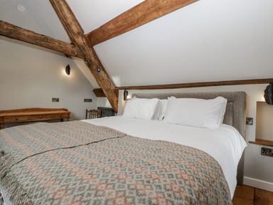A bedroom with a bed and wooden beams at 1 bed property Usk