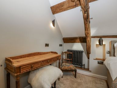 A bedroom with a desk, chair, and radiator at 1 bed property in Usk