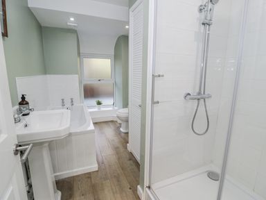 A bathroom with a bathtub, sink, and toilet at Haulfryn, Dolwyddelan