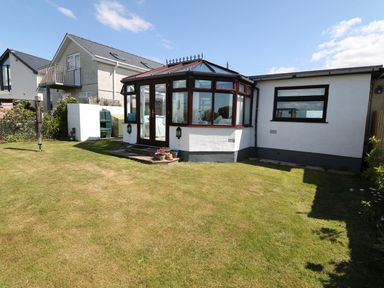 A garden with a conservatory and a house at Goetra
