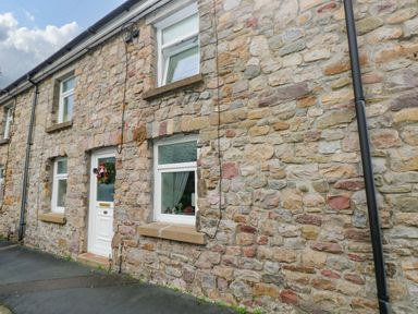 An outdoor view of a stone house at Tawe Cottage in Swansea