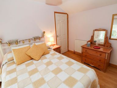 A bedroom with a bed and dressing table at Tawe Cottage Swansea