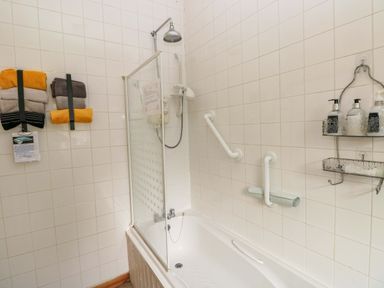 A bathroom with a bathtub and shower at Tawe Cottage Swansea