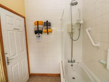A bathroom with a shower and towels at Tawe Cottage in Swansea