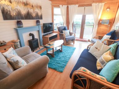 A living room with sofas and a television at Lamorna in Sennen