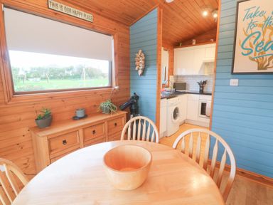 A kitchen with a dining table and chairs at Lamorna in Sennen