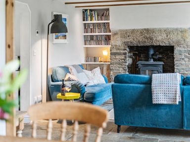 A living room with a sofa and a fireplace at Treovis Cottage in Callington