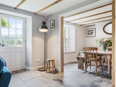 A dining room with a window and table at Treovis Cottage in Callington