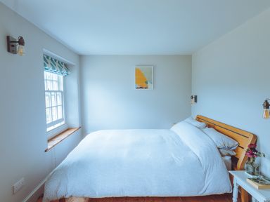 A bedroom with a bed and a window at Treovis Cottage in Callington