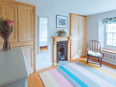 A living room with a flower vase and a fireplace at Treovis Cottage in Callington