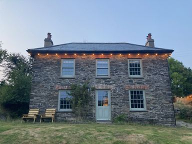 A house with windows and door surrounded by grass and trees at Treovis Cottage Callington