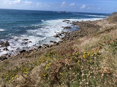 A coastal view with waves and rocks at Treovis Cottage in Callington