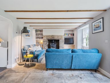 A living room with a sofa and a fireplace at Treovis Cottage Callington