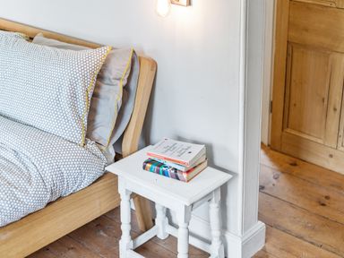 A bedroom with a bed and books on a nightstand at Treovis Cottage Callington