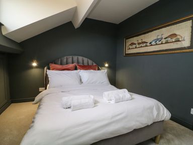 A bedroom with a bed and wall art at 2 Jade side in Malton