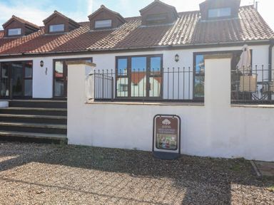 An outdoor area with a cottage, steps and a parking sign at East Cottage East Knapton near Rillington
