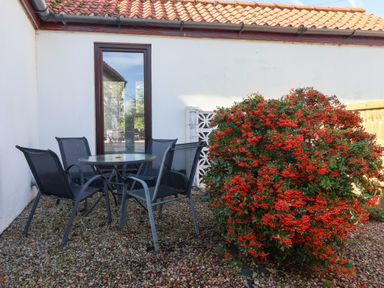 An outdoor seating area with a glass table and chairs at West Cottage East Knapton near Rillington