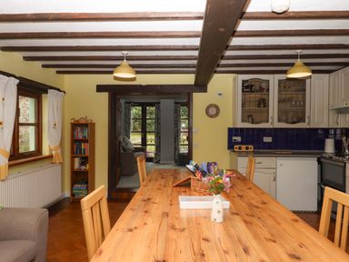 A kitchen with a dining table and chairs at The Milking Shippon at Thorne near Great Torrington