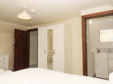 A bedroom with a wardrobe and sink at The Milking Shippon at Thorne near Great Torrington