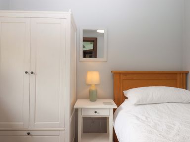A bedroom with a bed and bedside table at The Milking Shippon at Thorne near Great Torrington