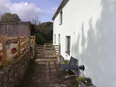 An outdoor area with a gate and chair at The Milking Shippon at Thorne near Great Torrington
