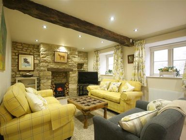 A living room with couches and a television at The Coach House in Burford