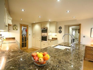 A kitchen with a countertop and appliances at The Coach House in Burford