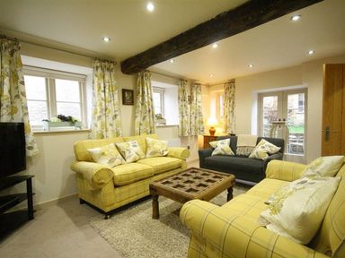 A living room with sofas and a coffee table at The Coach House in Burford