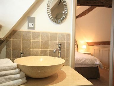 A bathroom with a wash basin and towels at The Coach House in Burford