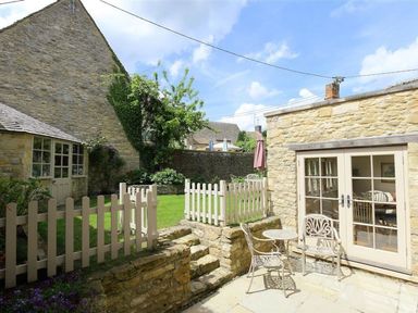 A garden with a table and chairs at The Coach House in Burford