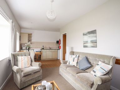 A living room with a kitchen area at Ceiriad - 9 Ty'n Don Llanengan near Abersoch