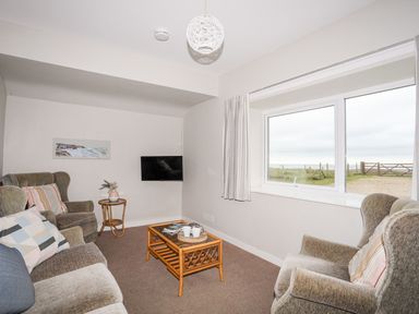 A living room with a sofa and television at Ceiriad - 9 Ty'n Don Llanengan near Abersoch