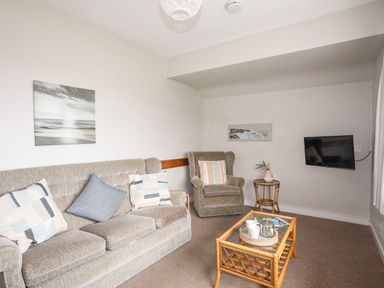 A living room with sofa, armchair, coffee table and television at Ceiriad - 9 Ty'n Don Llanengan near Abersoch