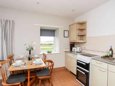 A kitchen with table and chairs at Ceiriad - 9 Ty'n Don near Llanengan