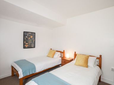 A bedroom with two single beds and a nightstand at Ceiriad - 9 Ty'n Don Llanengan near Abersoch