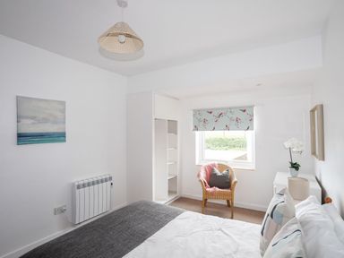 A bedroom with a bed and chair at Ceiriad - 9 Ty'n Don Llanengan near Abersoch