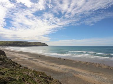 A beach with waves and people walking at Oer - 8 Ty'n Don Llanengan near Abersoch