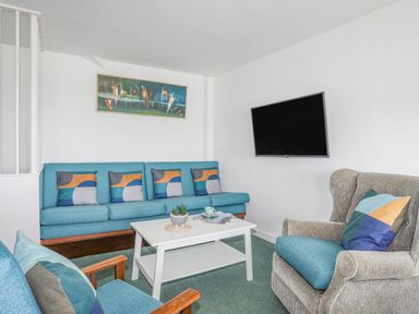 A living room with a sofa and an armchair at Ysgo - 6 Ty'n Don in Abersoch