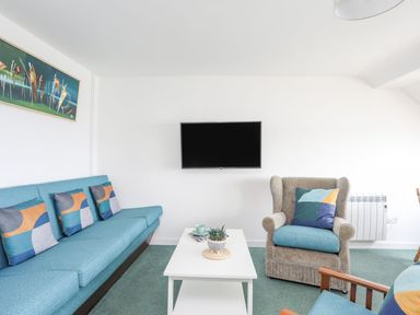A living room with a sofa and television at Ysgo - 6 Ty'n Don in Abersoch