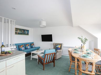 A living room with a sofa and dining table at Ysgo - 6 Ty'n Don in Abersoch