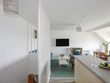A living room with a television and dining table at Ysgo - 6 Ty'n Don in Abersoch