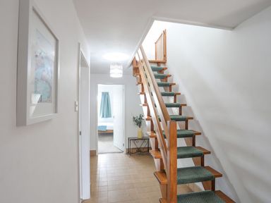 A hallway with stairs and a door at Ysgo - 6 Ty'n Don Abersoch