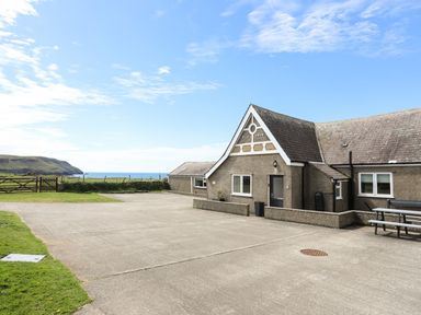 An outdoor area with a building and ocean view at Ysgo - 6 Ty'n Don in Abersoch
